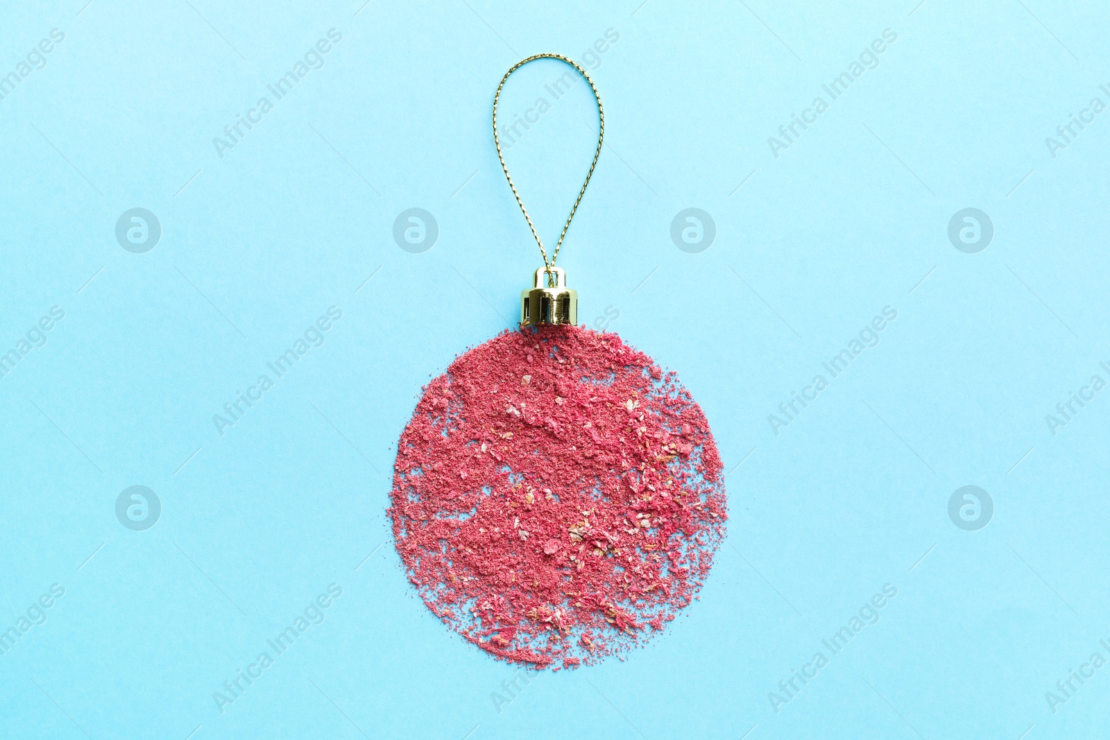 Photo of Christmas ball made with blush on light blue background, top view