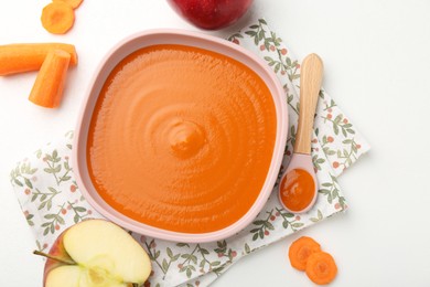 Photo of Delicious baby food in bowl and ingredients on white table, flat lay