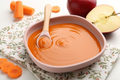 Photo of Delicious baby food in bowl and ingredients on white table