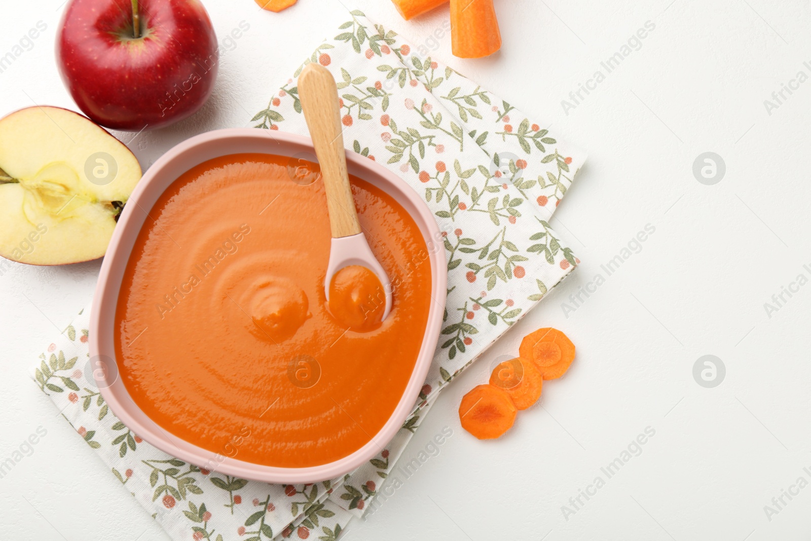 Photo of Delicious baby food in bowl and ingredients on white table, flat lay. Space for text