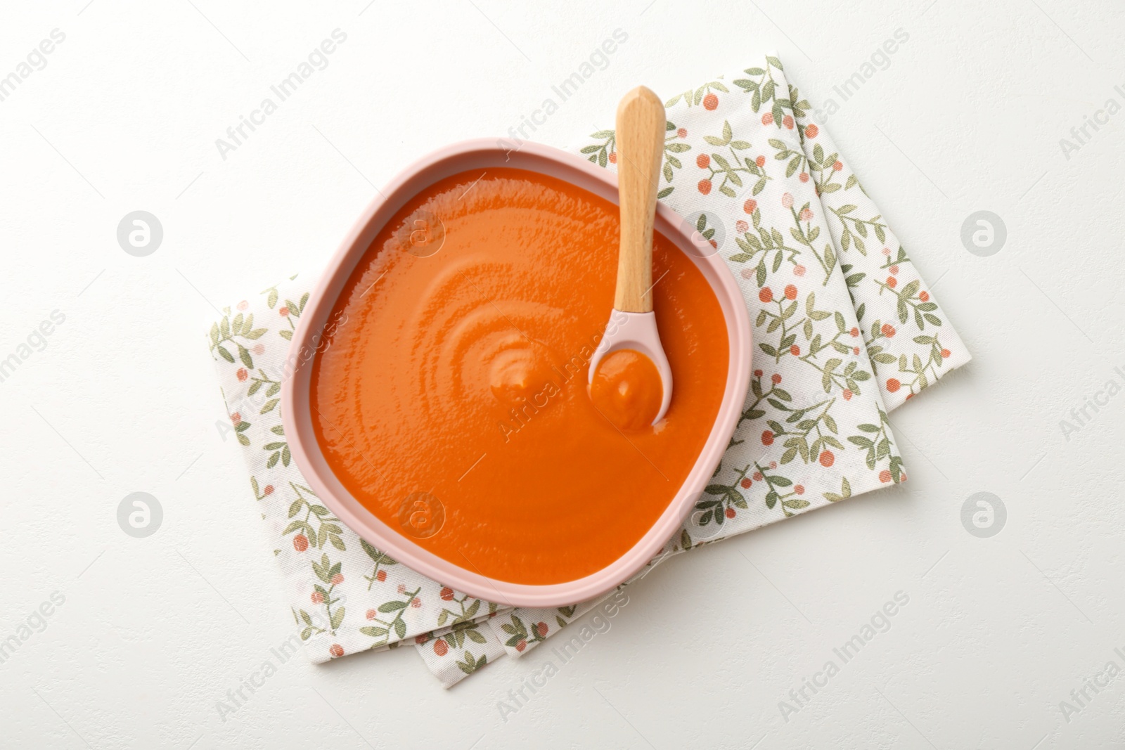 Photo of Delicious baby food in bowl on white table, top view