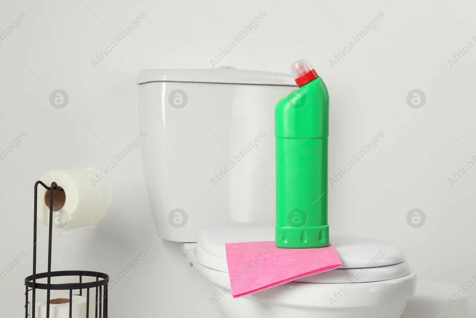 Photo of Detergent and rag on clean toilet in bathroom