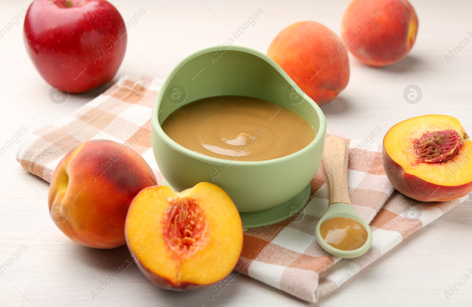 Photo of Delicious baby food in bowl and fresh ingredients on white wooden table