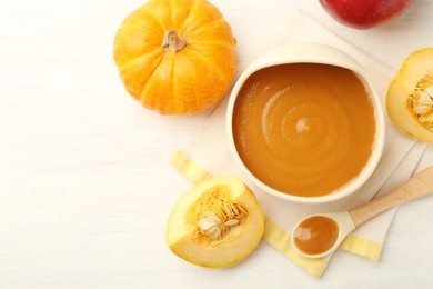 Photo of Delicious baby food in bowl and fresh ingredients on white wooden table, flat lay