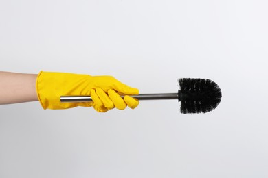 Photo of Woman holding black toilet brush on light background, closeup. Cleaning tool