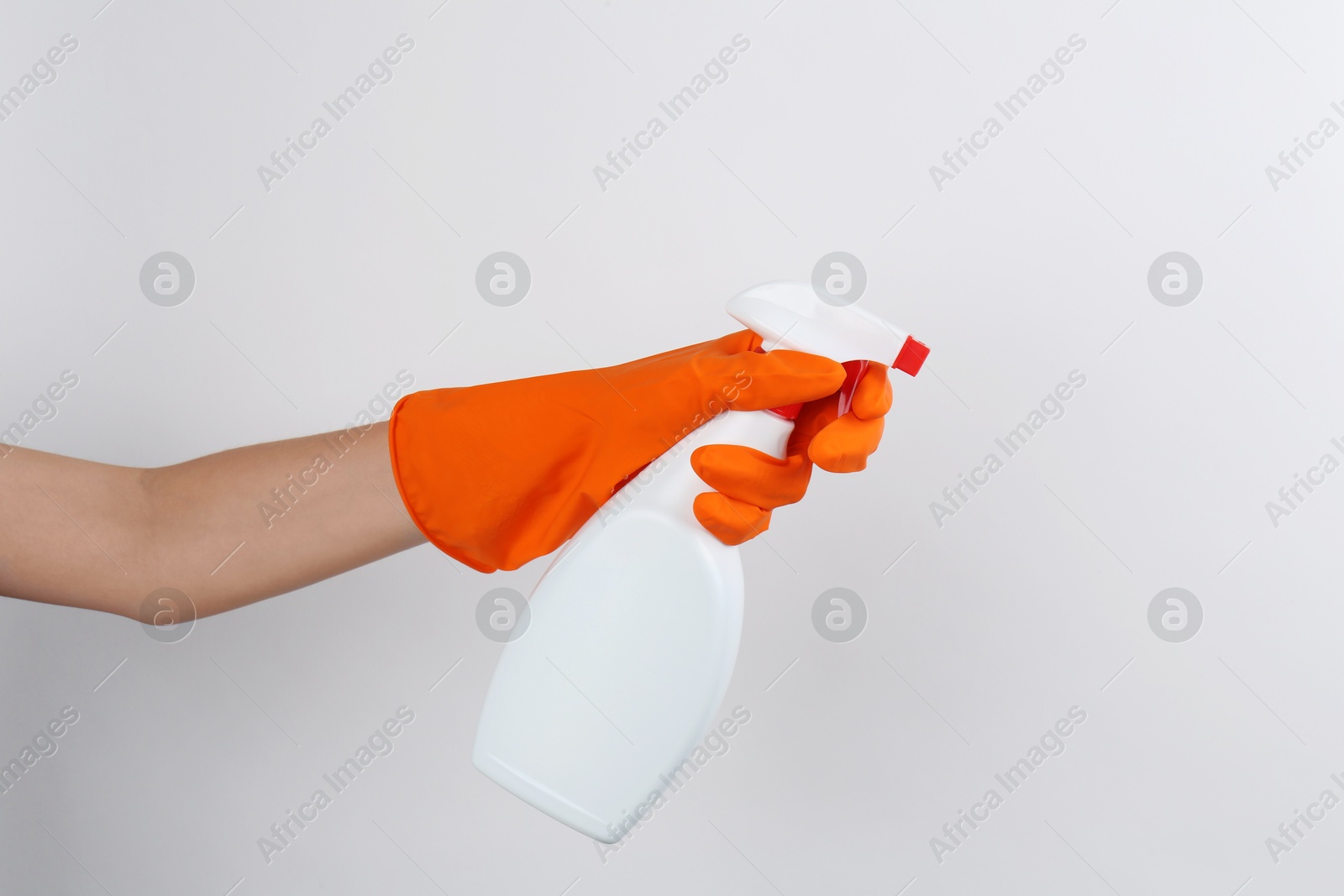 Photo of Woman holding toilet cleaner in spray bottle on light background, closeup