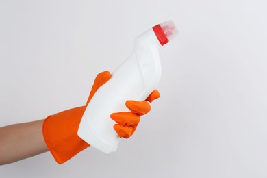 Photo of Woman holding toilet cleaner in bottle on light background, closeup