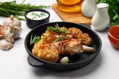 Photo of Delicious baked cauliflower steaks served on white tiled table