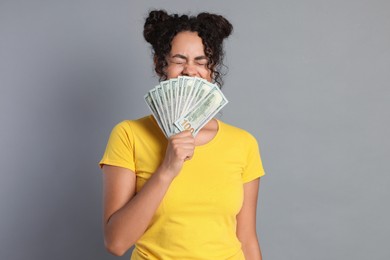 Photo of Woman with dollar banknotes on grey background