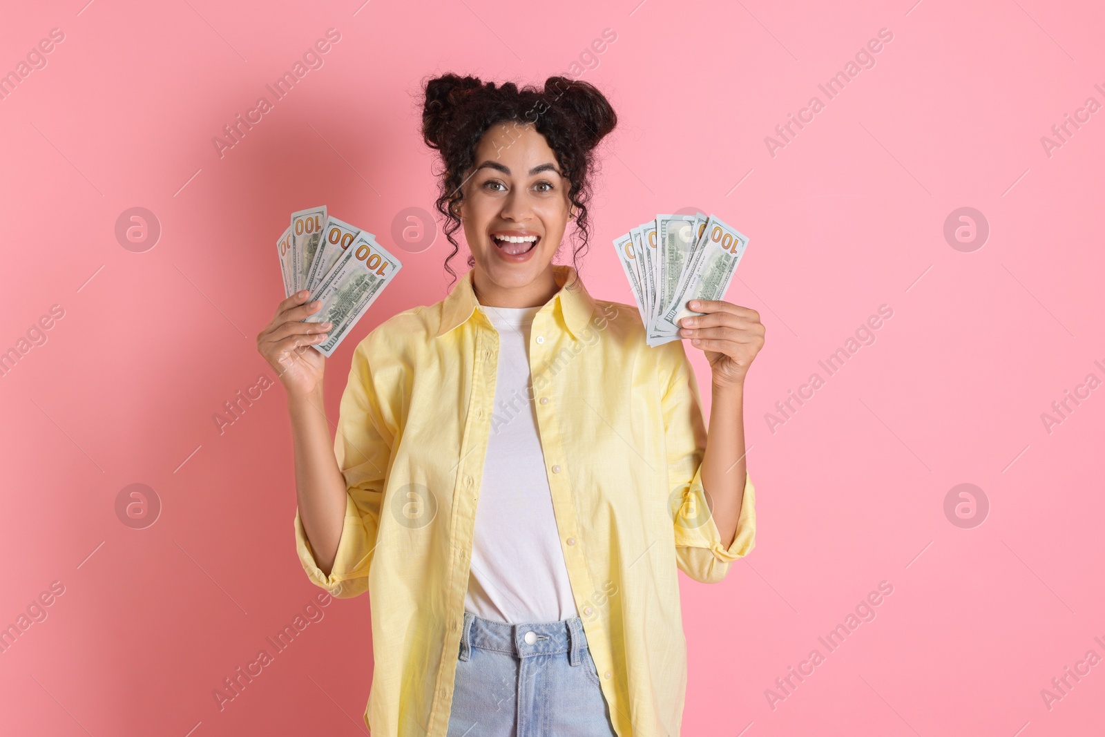 Photo of Happy woman with dollar banknotes on pink background