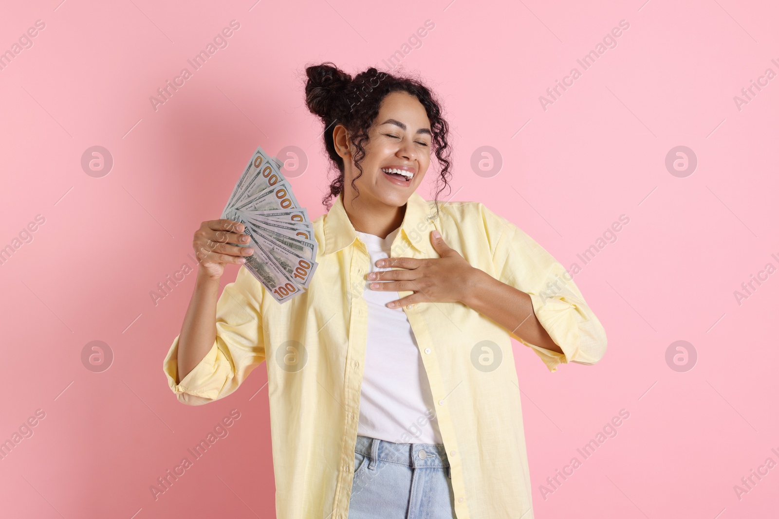 Photo of Happy woman with dollar banknotes on pink background