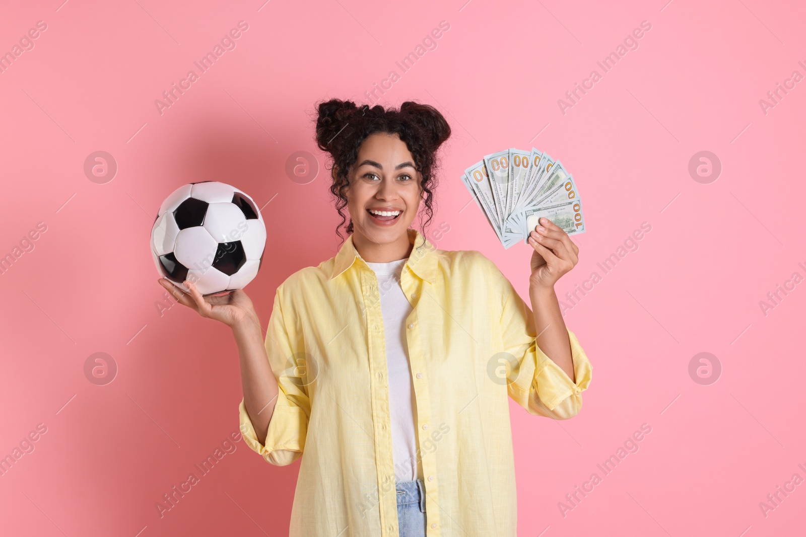 Photo of Happy woman with money and soccer ball on pink background