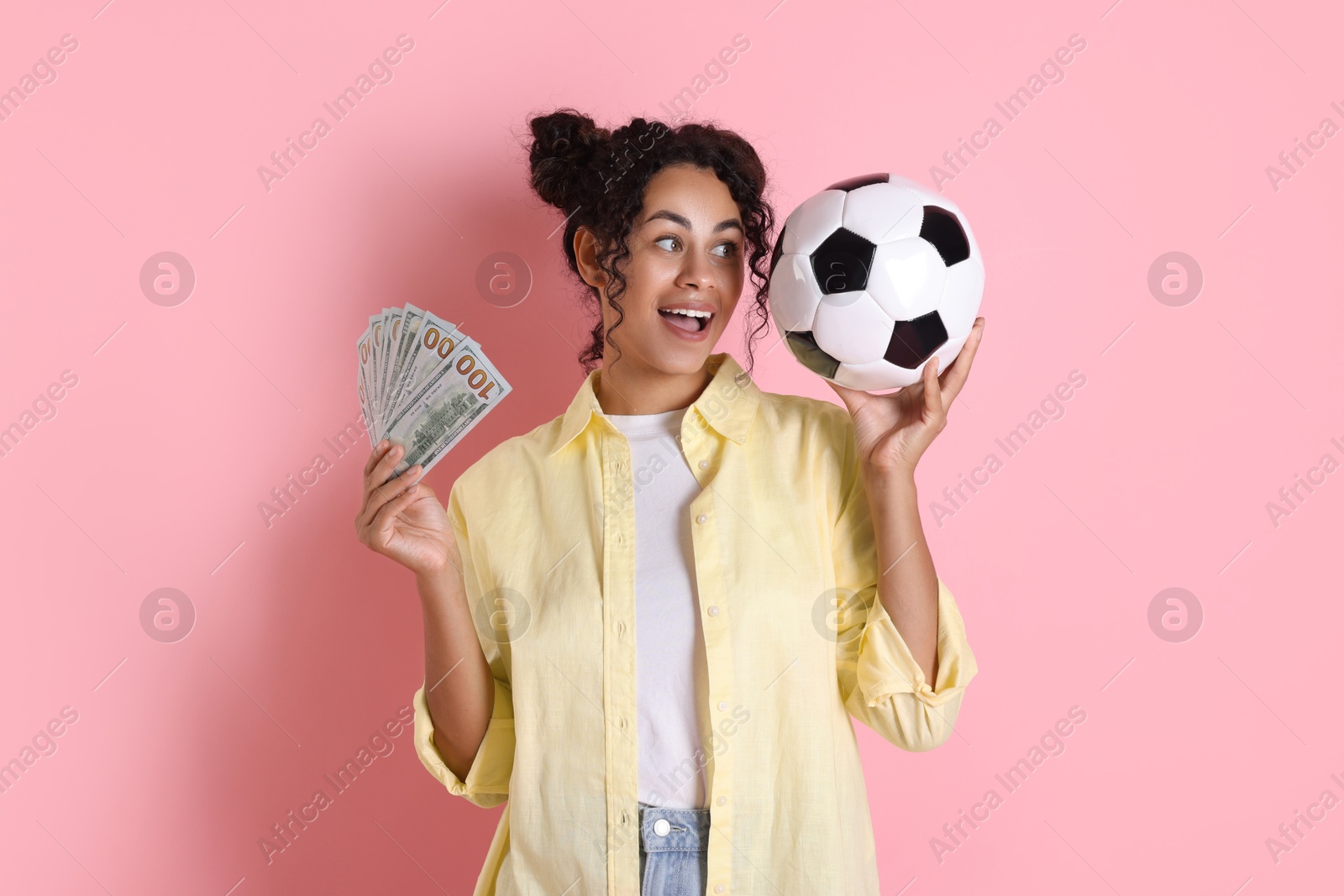 Photo of Happy woman with money and soccer ball on pink background