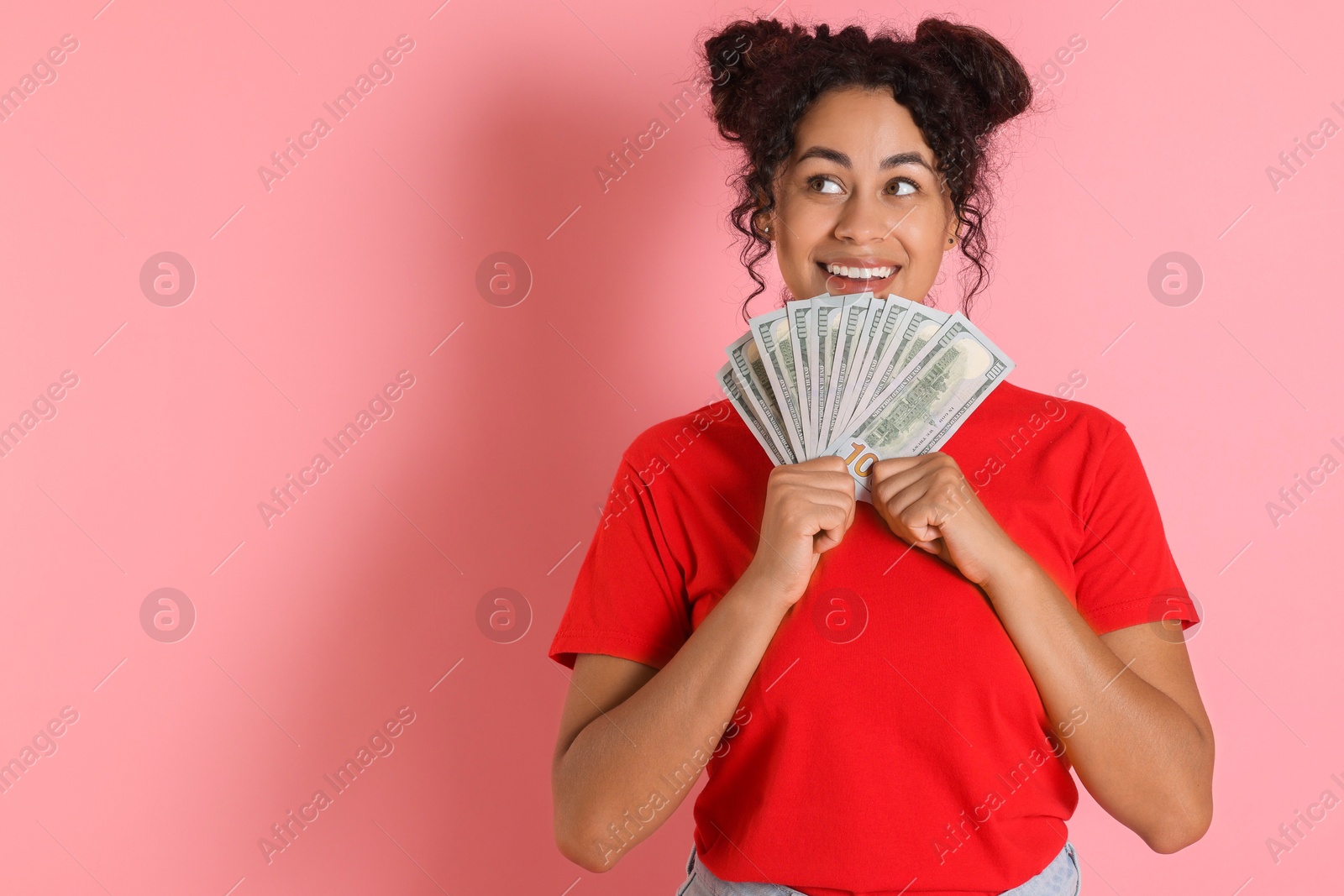 Photo of Happy woman with dollar banknotes on pink background, space for text