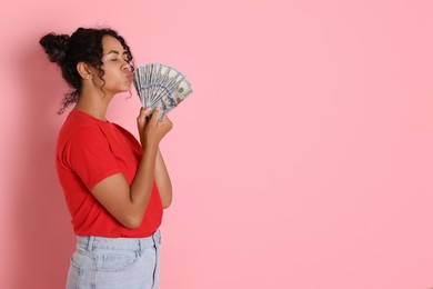 Woman with dollar banknotes on pink background, space for text