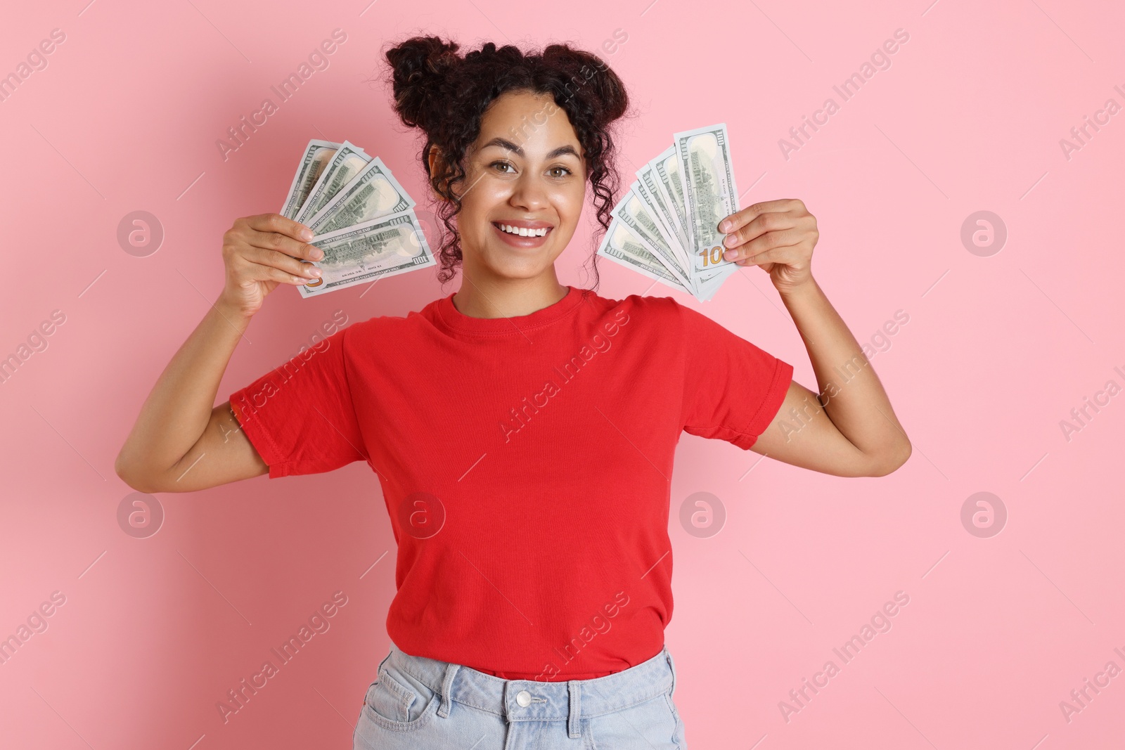 Photo of Happy woman with dollar banknotes on pink background