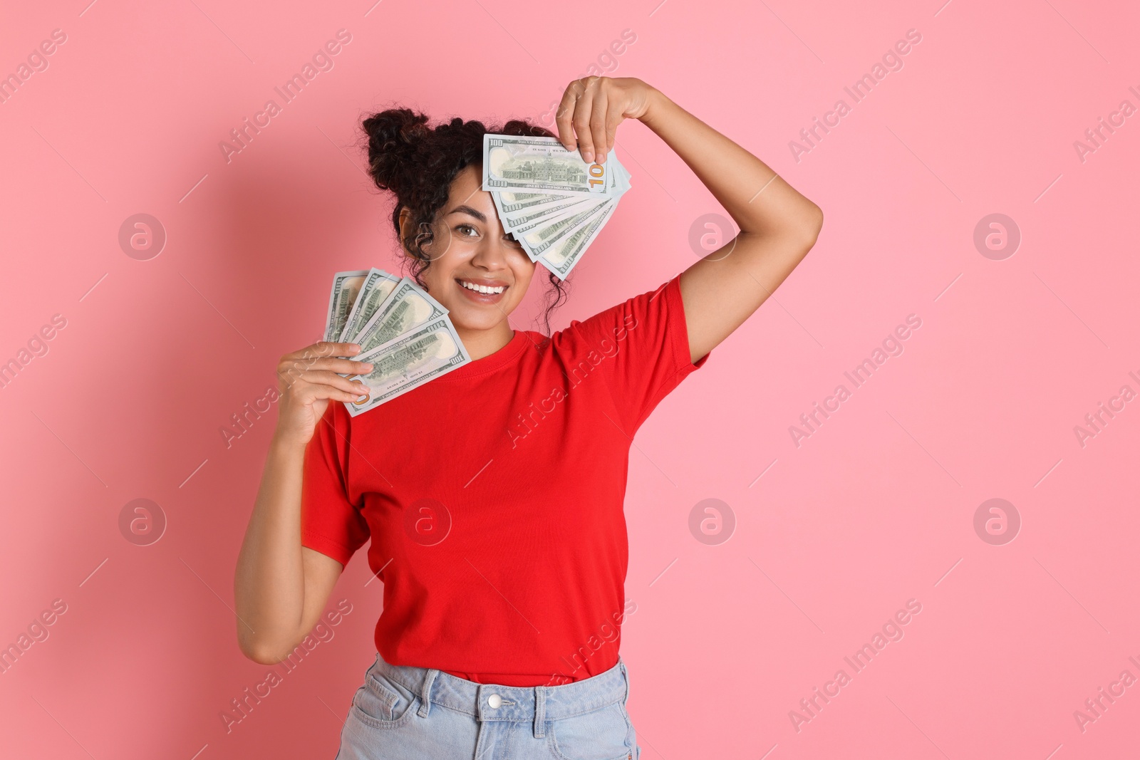 Photo of Happy woman with dollar banknotes on pink background