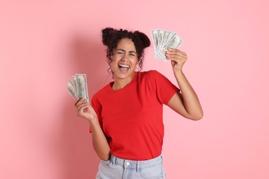 Happy woman with dollar banknotes on pink background