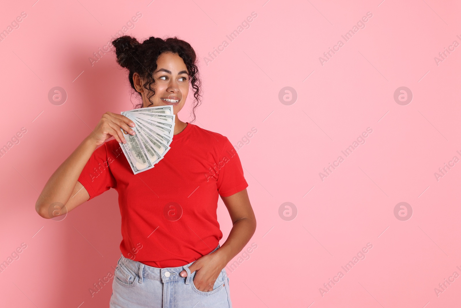 Photo of Happy woman with dollar banknotes on pink background, space for text