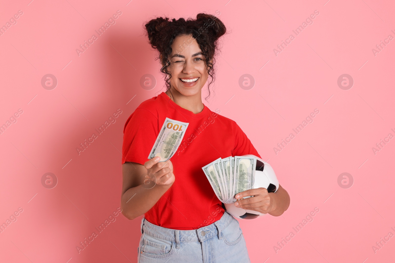 Photo of Happy woman with money and soccer ball on pink background