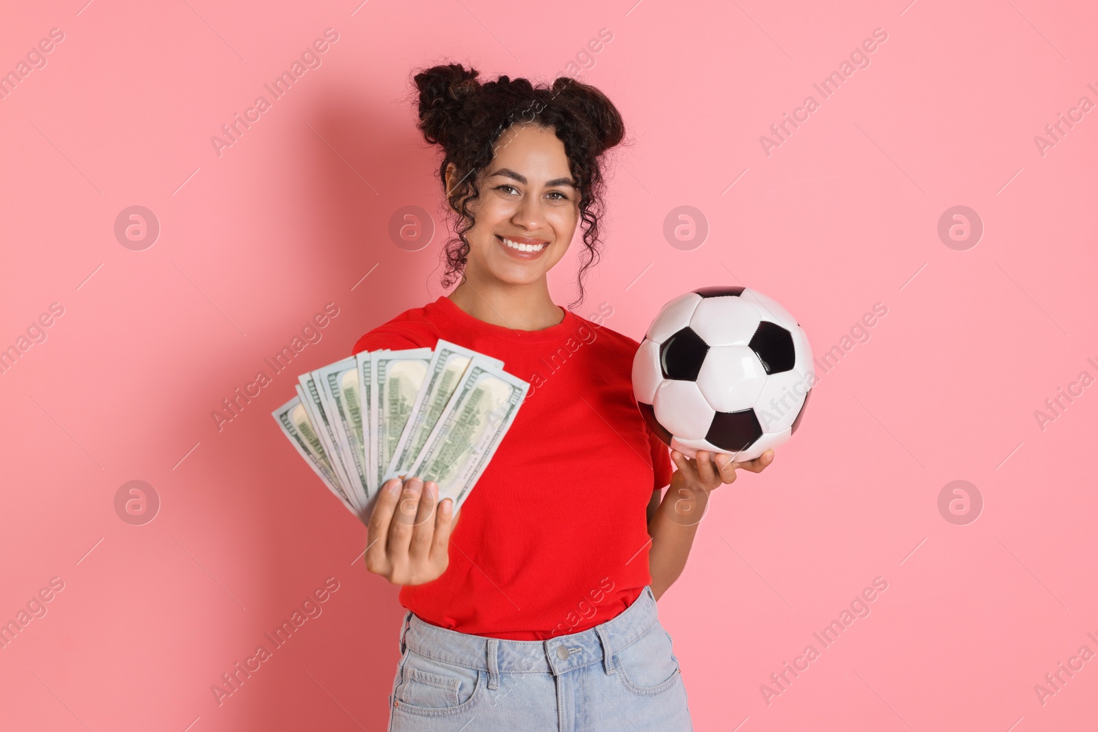 Photo of Happy woman with money and soccer ball on pink background