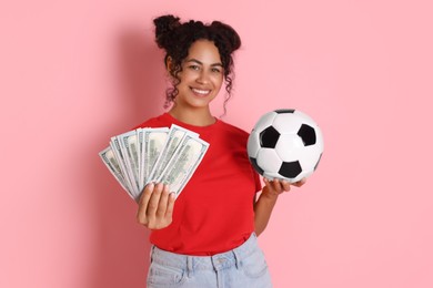 Photo of Happy woman with money and soccer ball on pink background