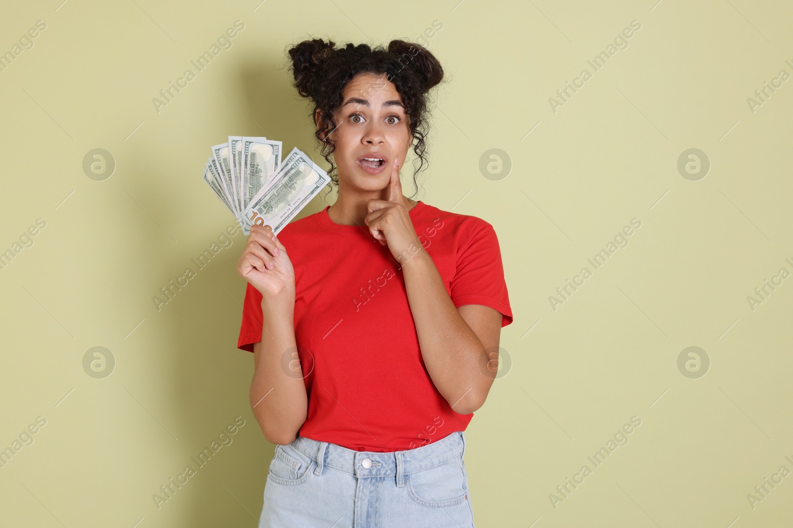 Photo of Woman with dollar banknotes on pale green background