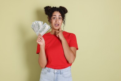 Woman with dollar banknotes on pale green background