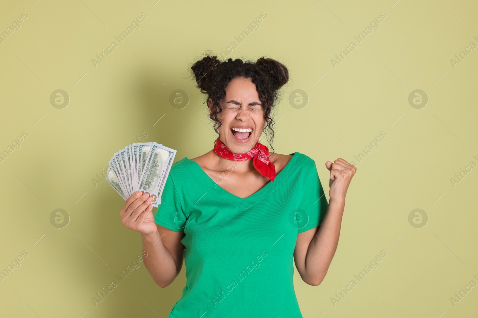 Photo of Happy woman with dollar banknotes on pale green background