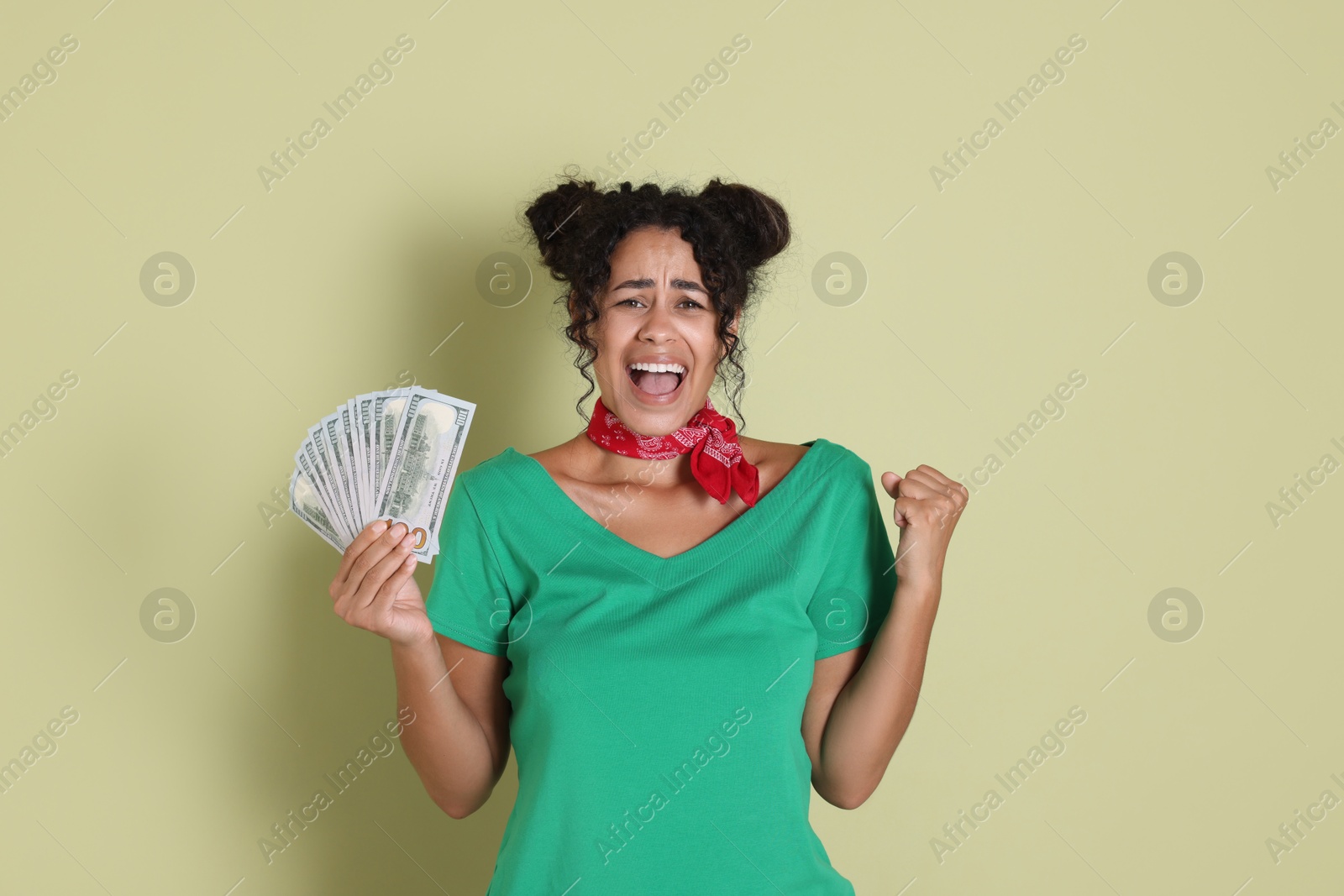 Photo of Happy woman with dollar banknotes on pale green background