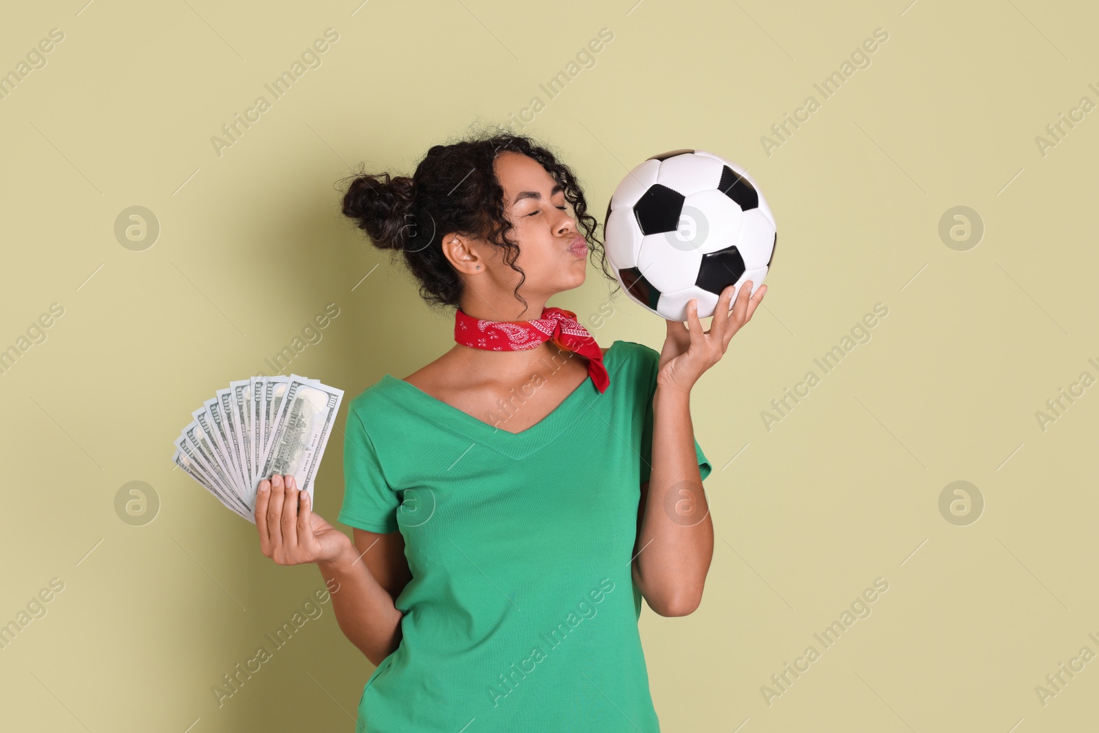 Photo of Woman with money and soccer ball on pale green background