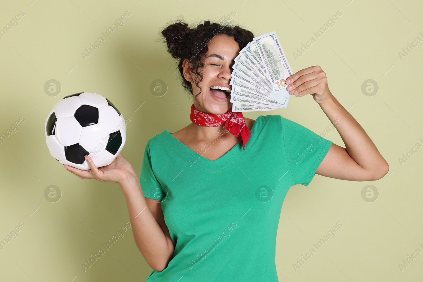 Photo of Happy woman with money and soccer ball on pale green background