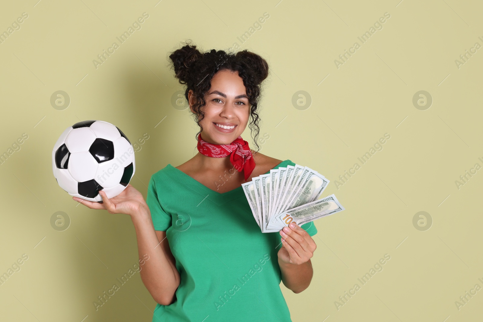 Photo of Happy woman with money and soccer ball on pale green background