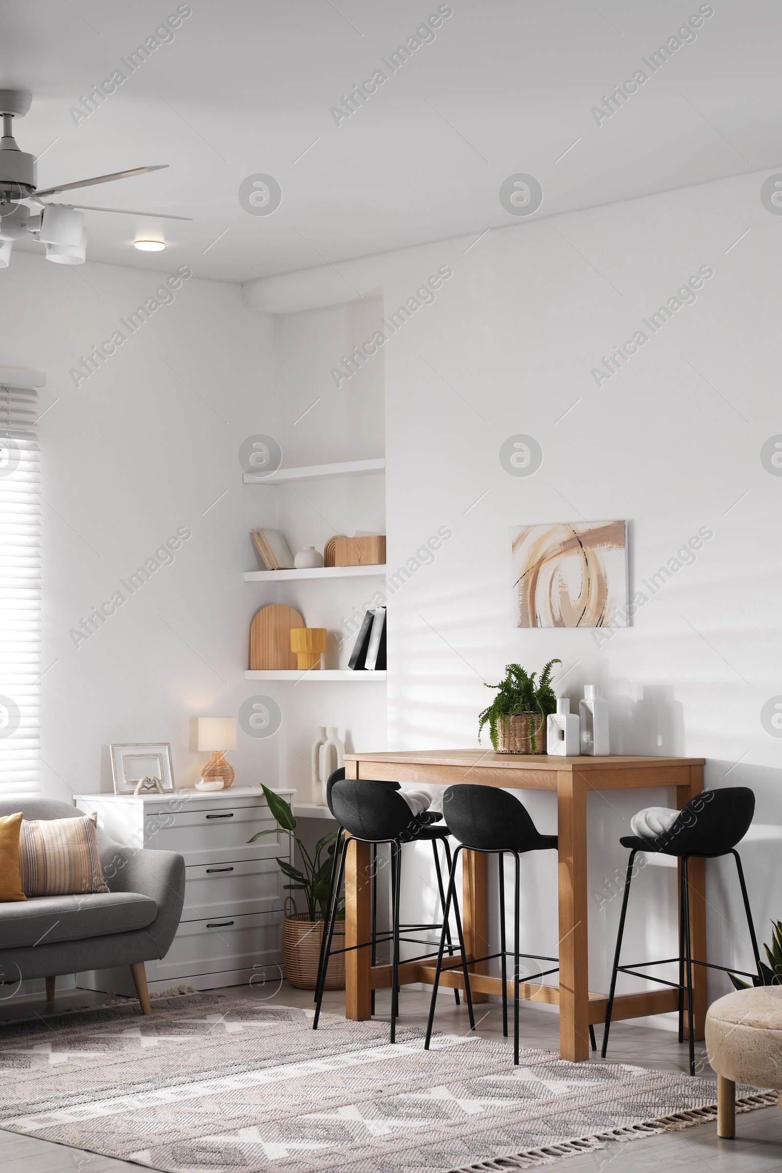 Photo of Bar stools near table in room. Interior design