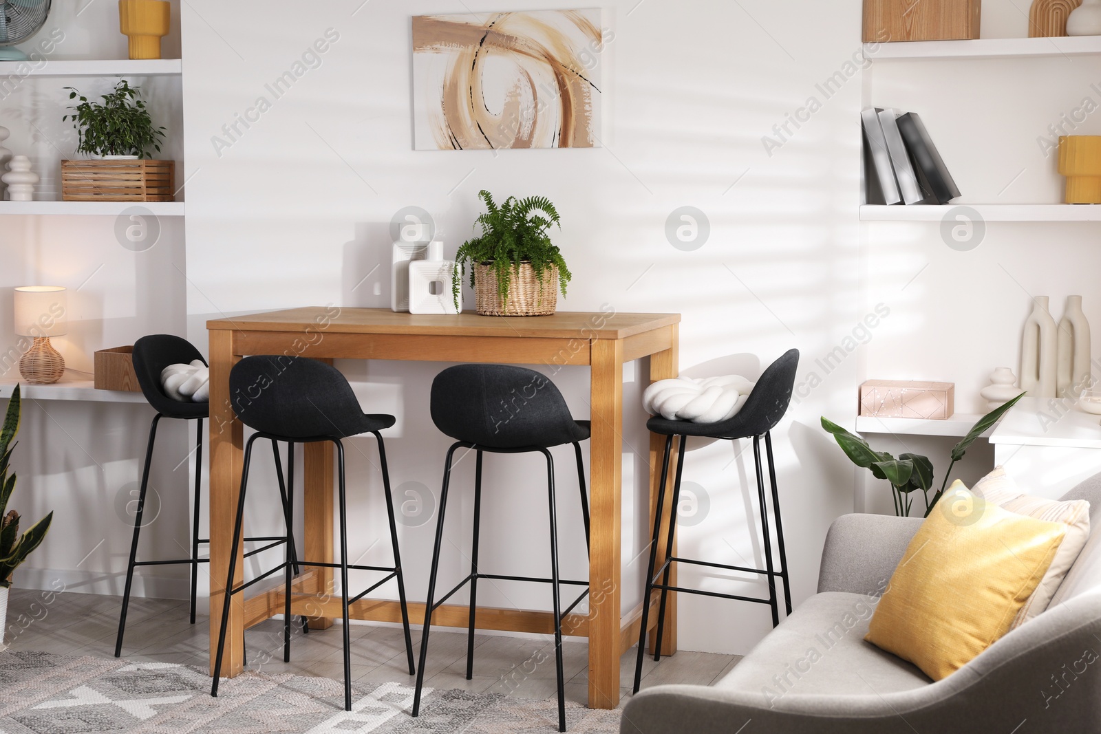 Photo of Bar stools near table in room. Interior design