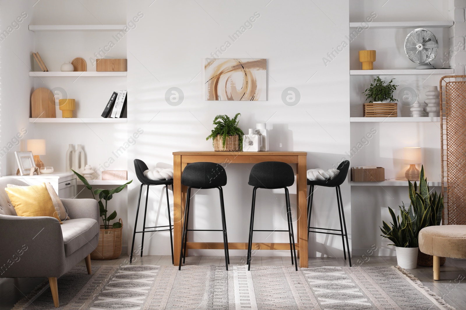 Photo of Bar stools near table in room. Interior design