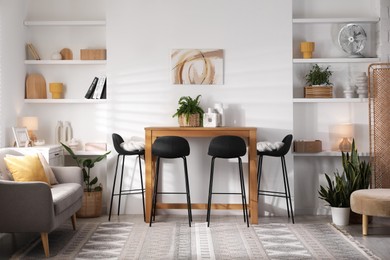 Bar stools near table in room. Interior design