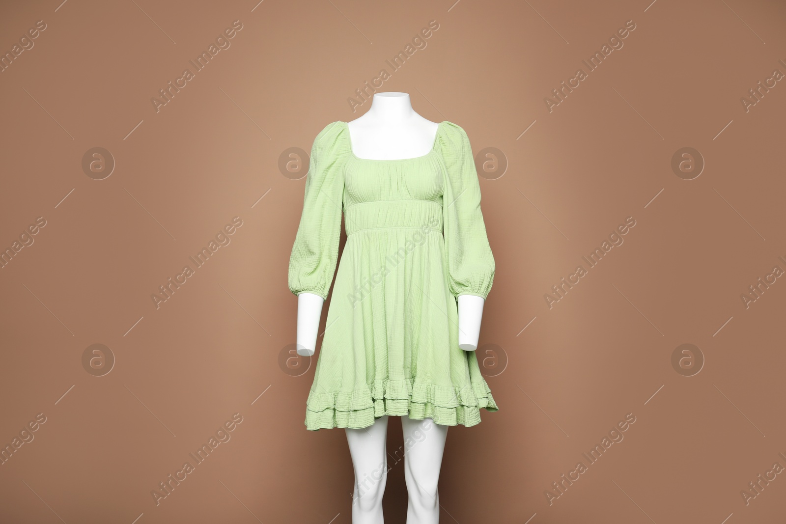 Photo of Female mannequin with stylish dress on light brown background