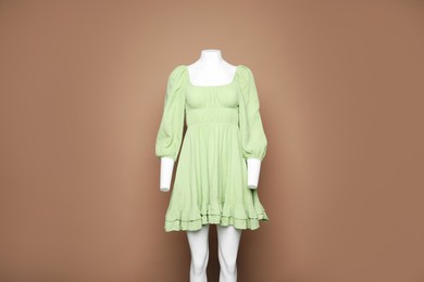 Photo of Female mannequin with stylish dress on light brown background