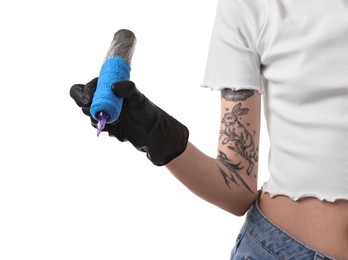 Photo of Professional artist in gloves holding tattoo machine on white background, closeup