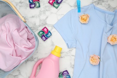 Photo of Flat lay composition with laundry detergents, rose flowers and t-shirts on white marble table