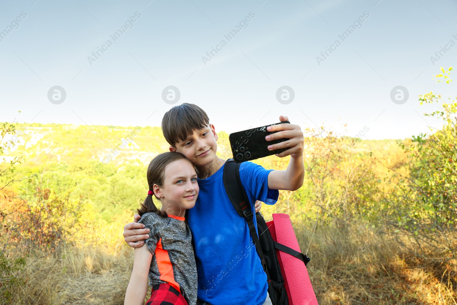 Photo of Brother taking selfie with his sister outdoors