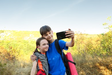 Photo of Brother taking selfie with his sister outdoors