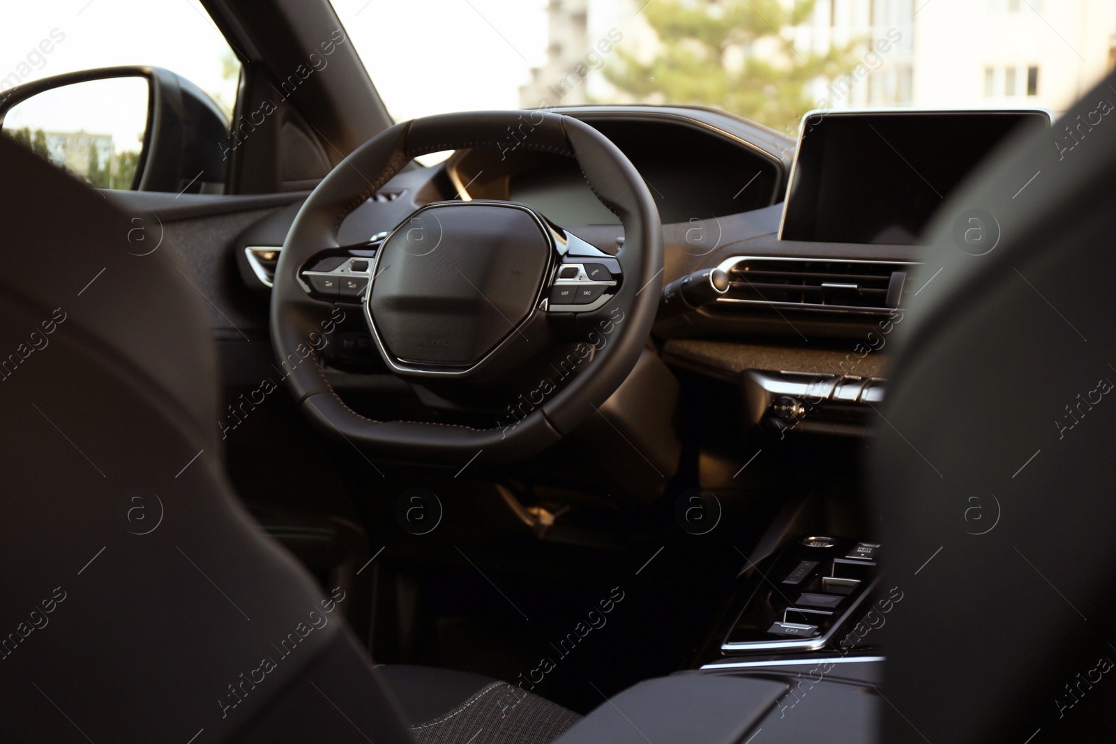 Photo of Steering wheel and dashboard inside of modern luxury car, closeup