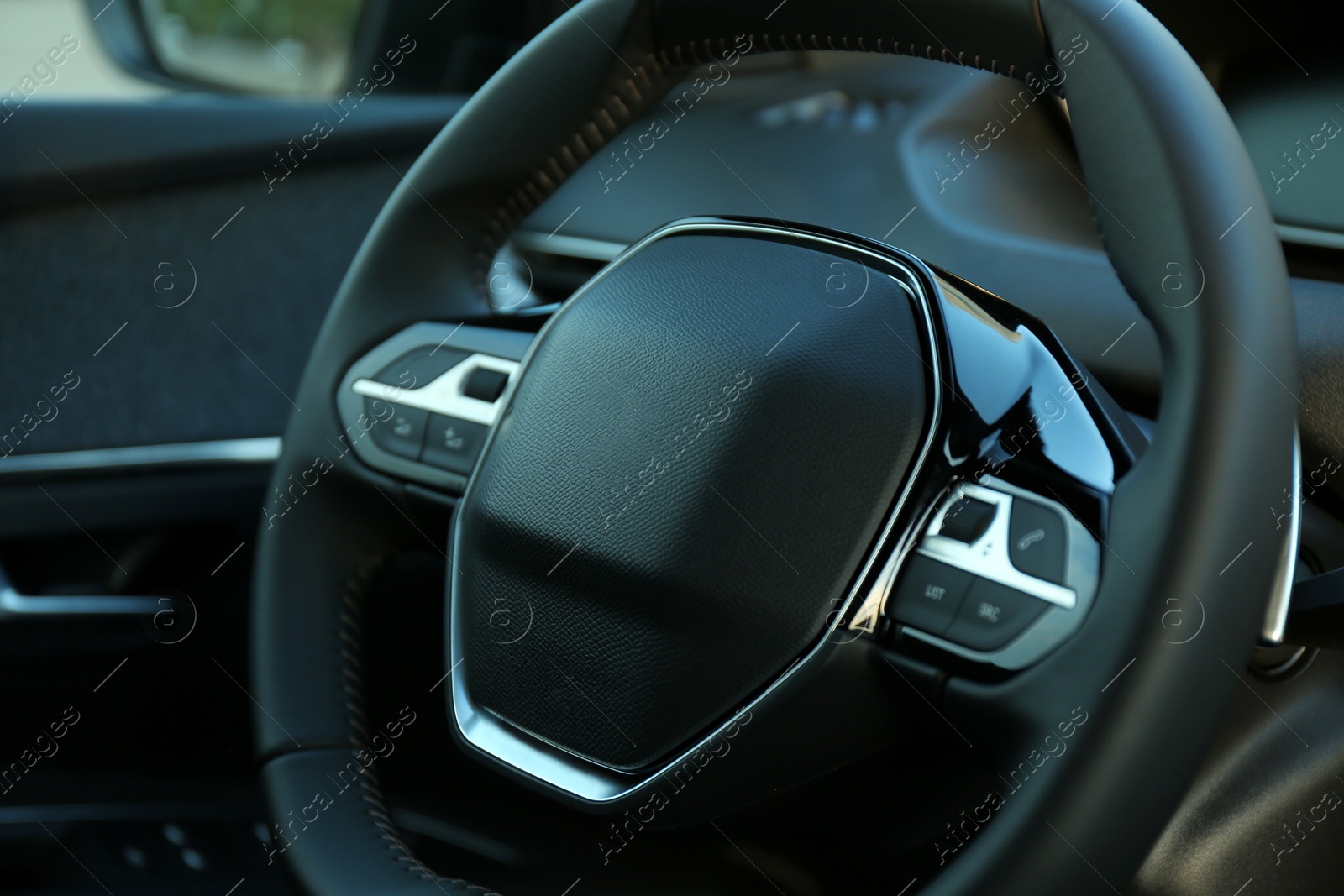 Photo of Steering wheel inside of modern luxury car, closeup