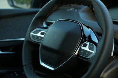 Photo of Steering wheel inside of modern luxury car, closeup