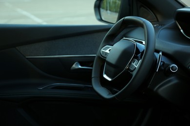 Photo of Steering wheel and dashboard inside of modern luxury car, closeup. Space for text