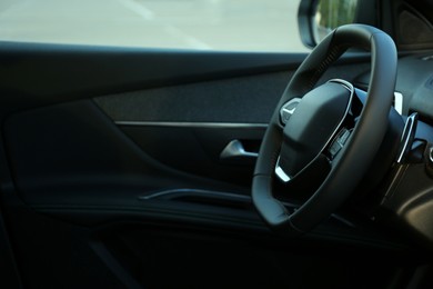 Steering wheel and dashboard inside of modern luxury car, closeup. Space for text