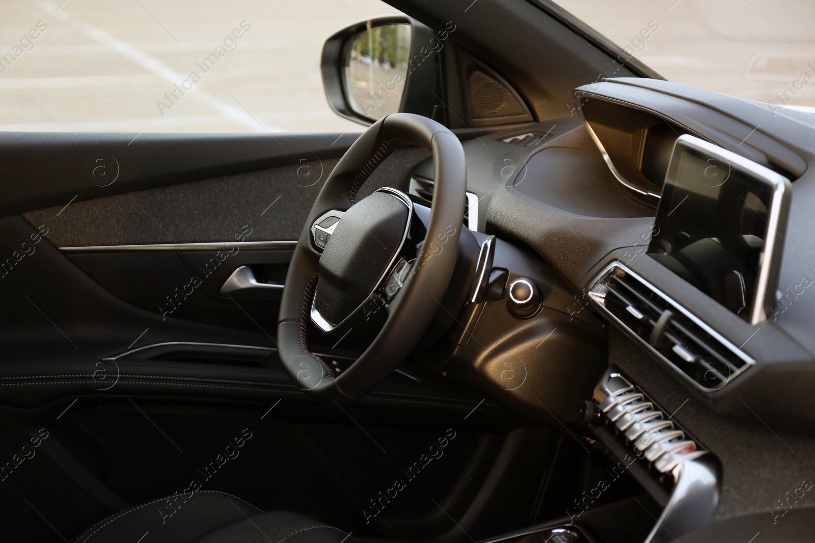 Photo of Steering wheel and dashboard inside of modern luxury car, closeup