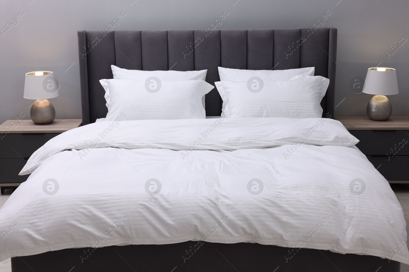 Photo of Bed with clean linens and pillows indoors